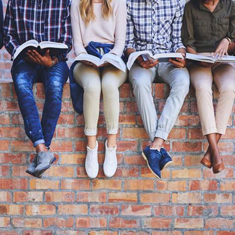 Several students sitting on a wall