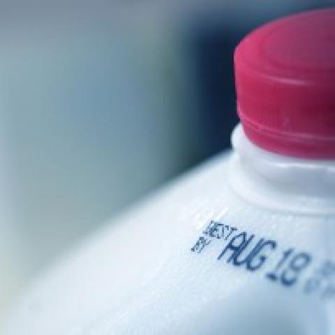 A food expiration date is displayed atop a 1-gallon milk jug